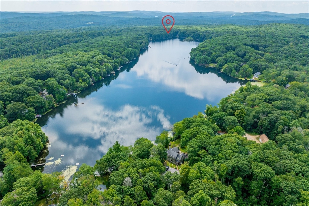 an aerial view of a house with a yard and lake view