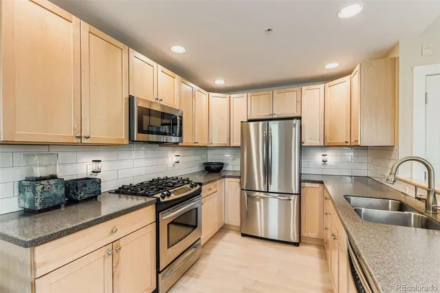 a kitchen with stainless steel appliances granite countertop a refrigerator sink and microwave