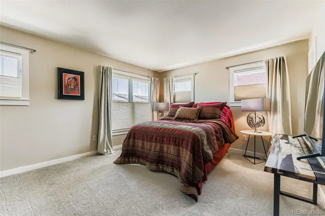 a spacious bedroom with a bed and glass window