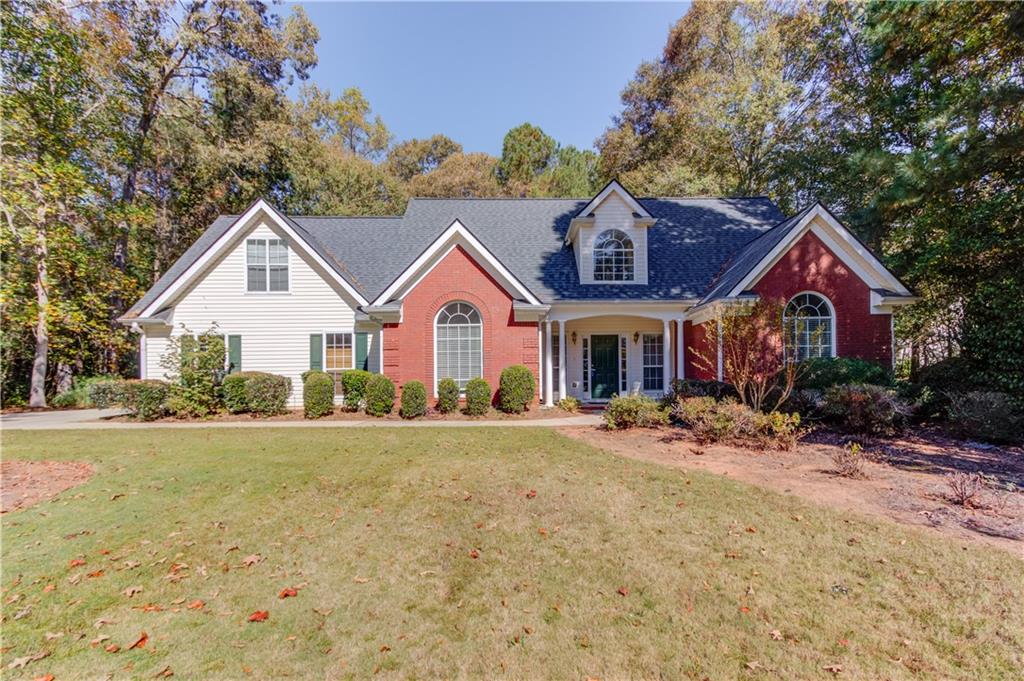 a front view of a house with yard and green space