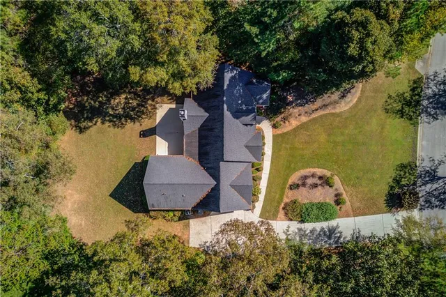 an aerial view of a house with a yard and lake view