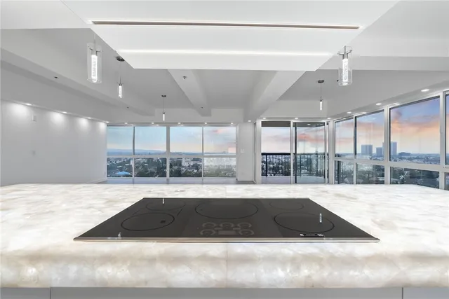 a large white kitchen with wooden floor and large windows