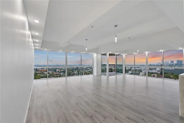a view of a big room with wooden floor and a kitchen