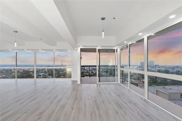 an empty room with wooden floor and glass door