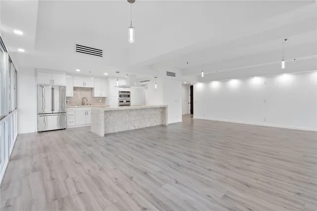 a view of an empty room with wooden floor