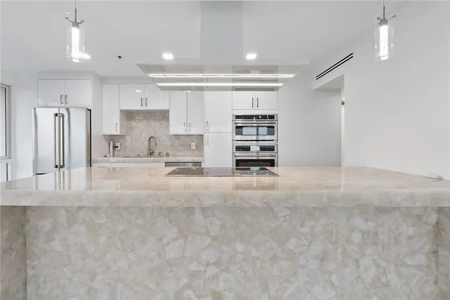 a view of kitchen with stainless steel appliances cabinets