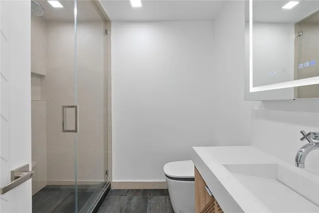 a white toilet sitting next to a shower