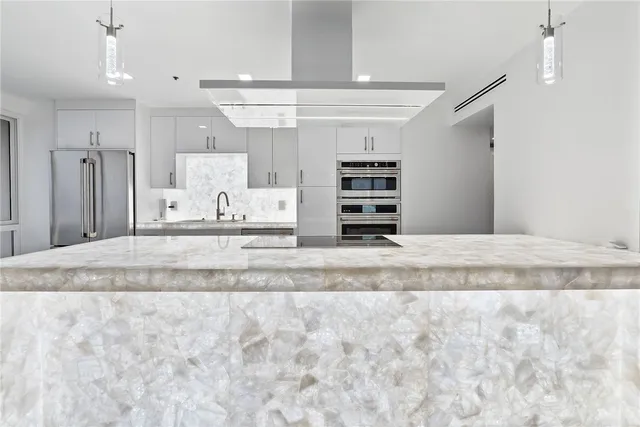 a view of kitchen with stainless steel appliances kitchen island granite countertop a refrigerator and a sink
