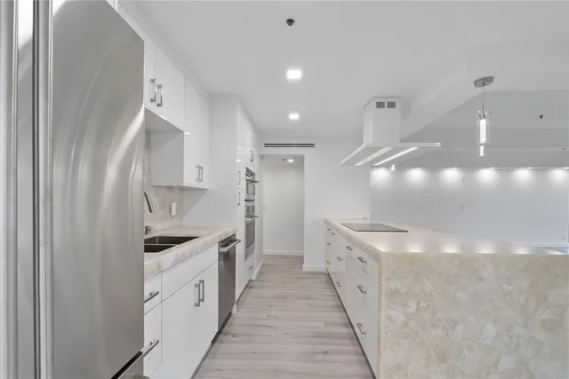 a close view of a sink and dishwasher with a kitchen island in it