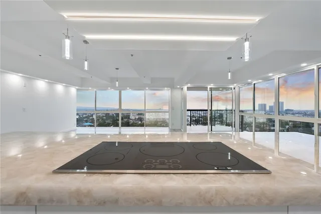 a view of an empty room with wooden floor and windows