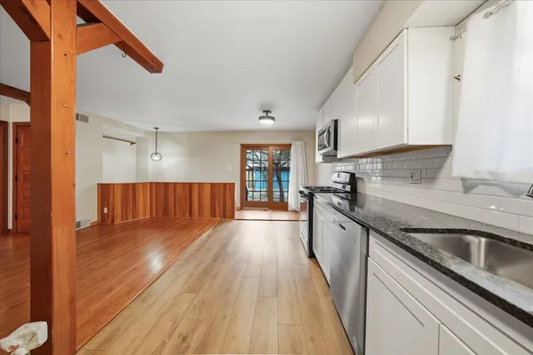 a kitchen with granite countertop a sink and steel appliances