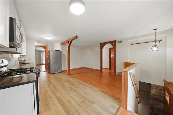 a view of a kitchen with a stove wooden floor and a kitchen