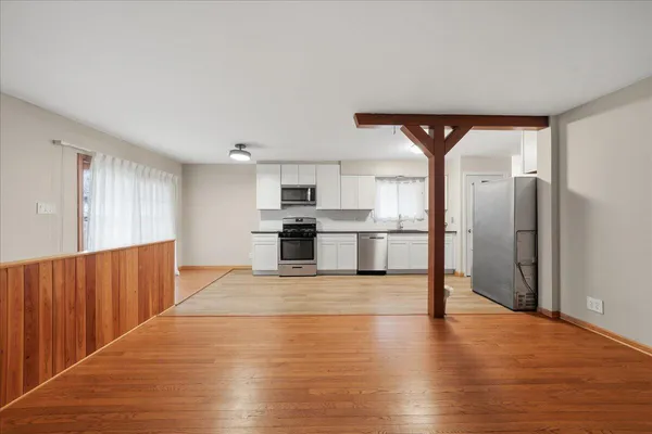 a view of kitchen with wooden floor and electronic appliances