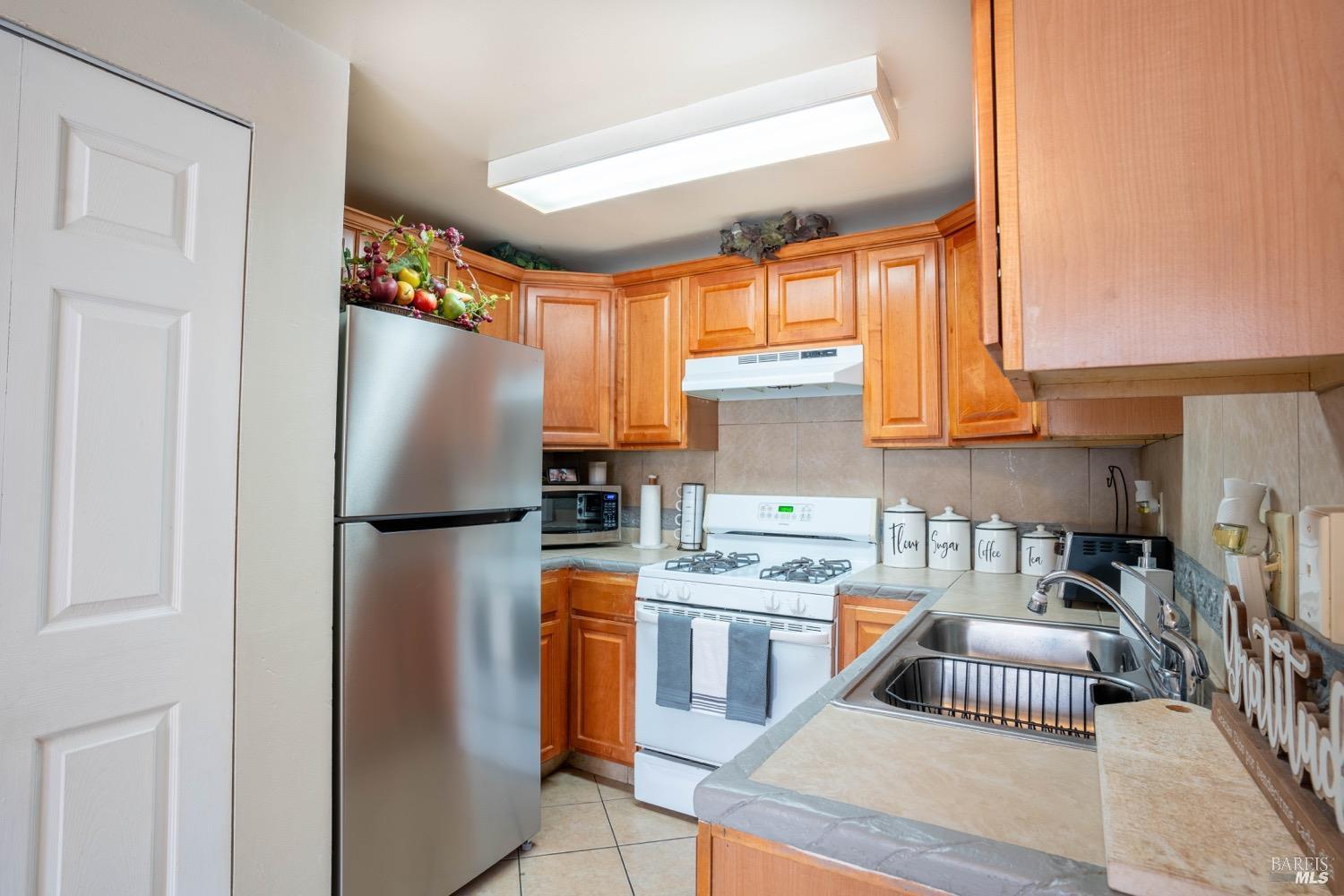 237 Del Loma Court Fairfield, CA 94533 - Photo 7 of 15 a kitchen with stainless steel appliances granite countertop a refrigerator sink and white cabinets