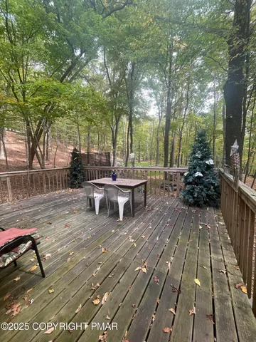 a view of a patio with table and chairs wooden floor and fence