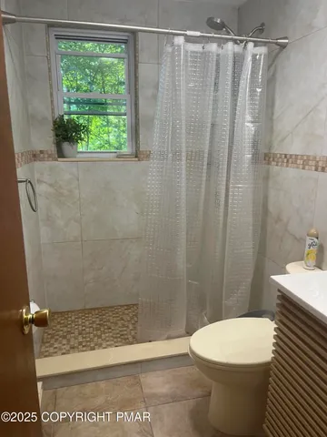 a bathroom with a shower a toilet and a shower
