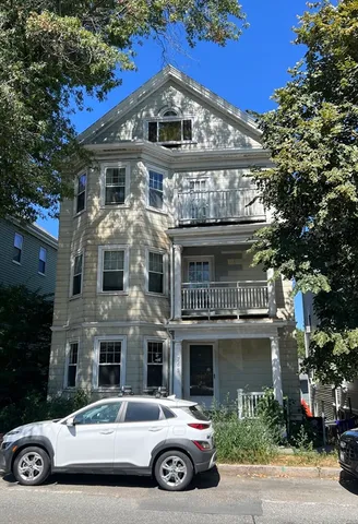 a view of a car parked in front of a brick house