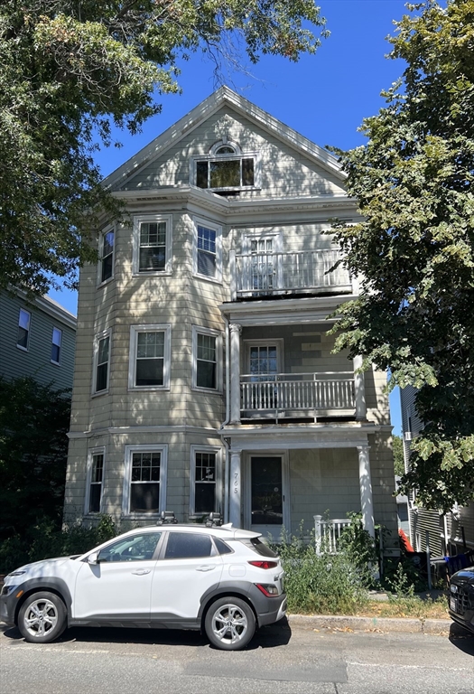a view of a car parked in front of a brick house