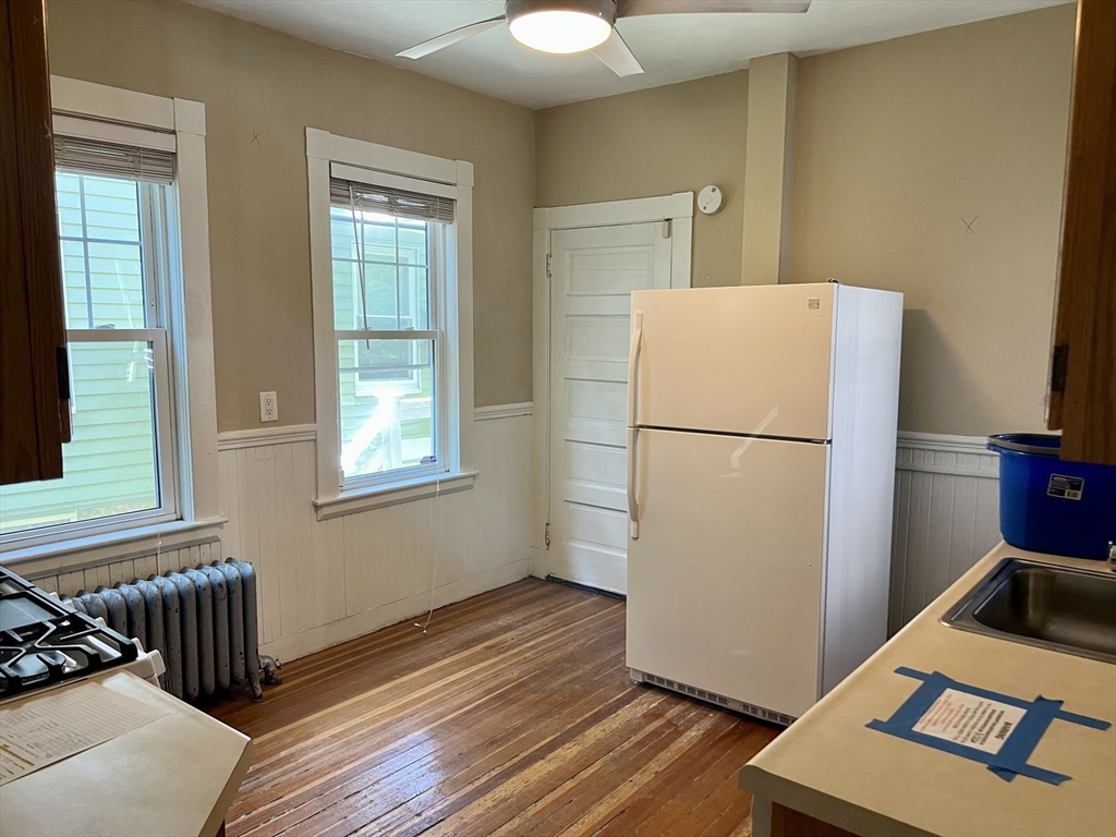 765 Boylston Street, Unit 1 Brookline, MA 02467 - Photo 3 of 12 a view of a kitchen with wooden floor and a refrigerator