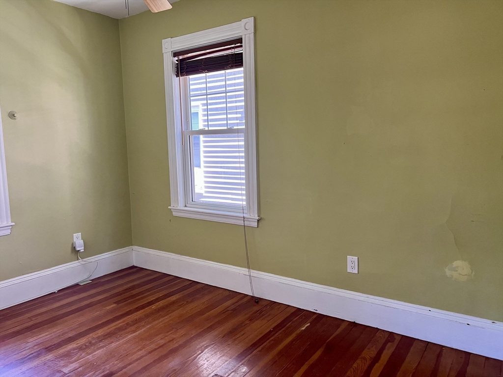 765 Boylston Street, Unit 1 Brookline, MA 02467 - Photo 7 of 12 a view of empty room with wooden floor and fan