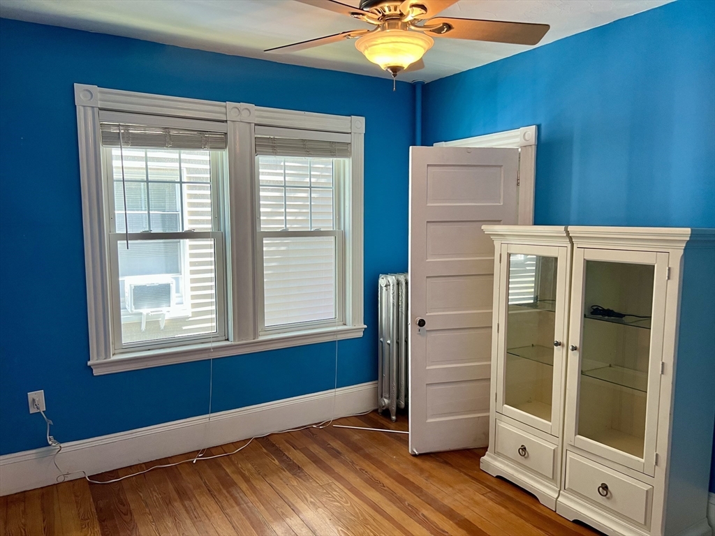 765 Boylston Street, Unit 1 Brookline, MA 02467 - Photo 9 of 12 a view of an empty room with wooden floor and a window