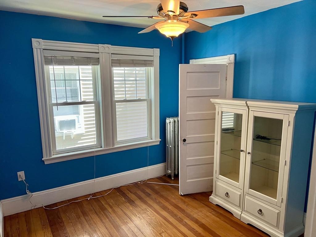 765 Boylston Street, Unit 1 Brookline, MA 02467 - Photo 10 of 12 a view of empty room with wooden floor and fan