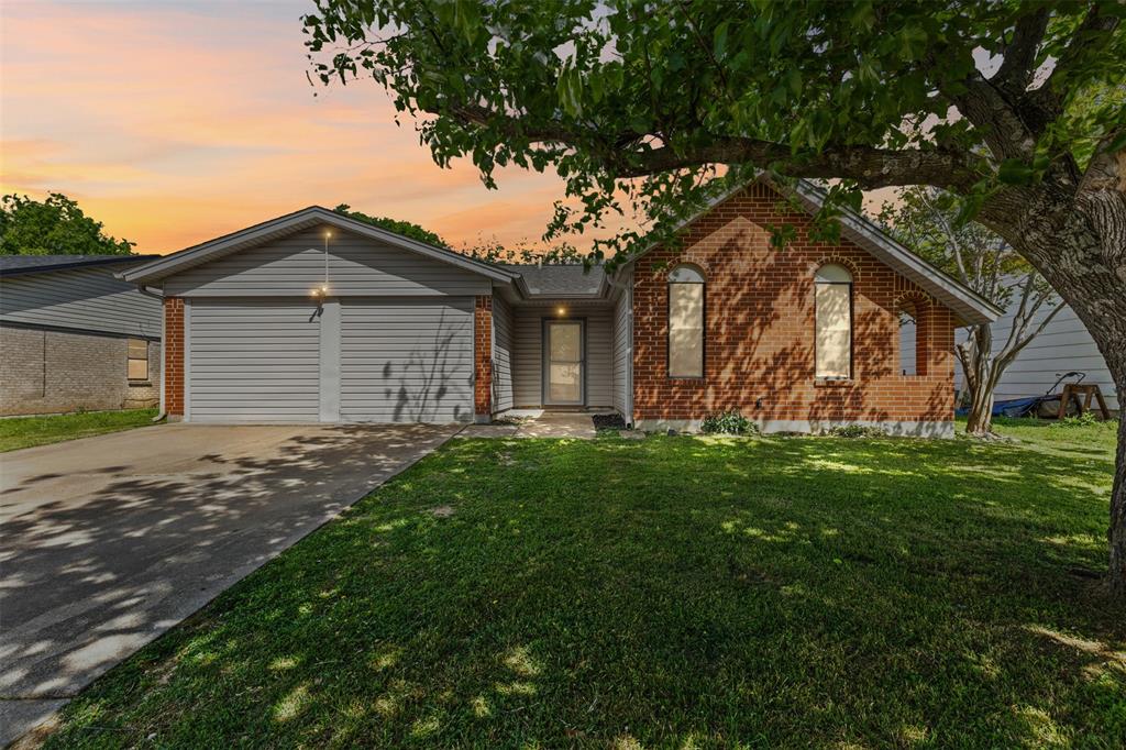 Ranch-style house featuring a lawn, brick siding, driveway, and a garage