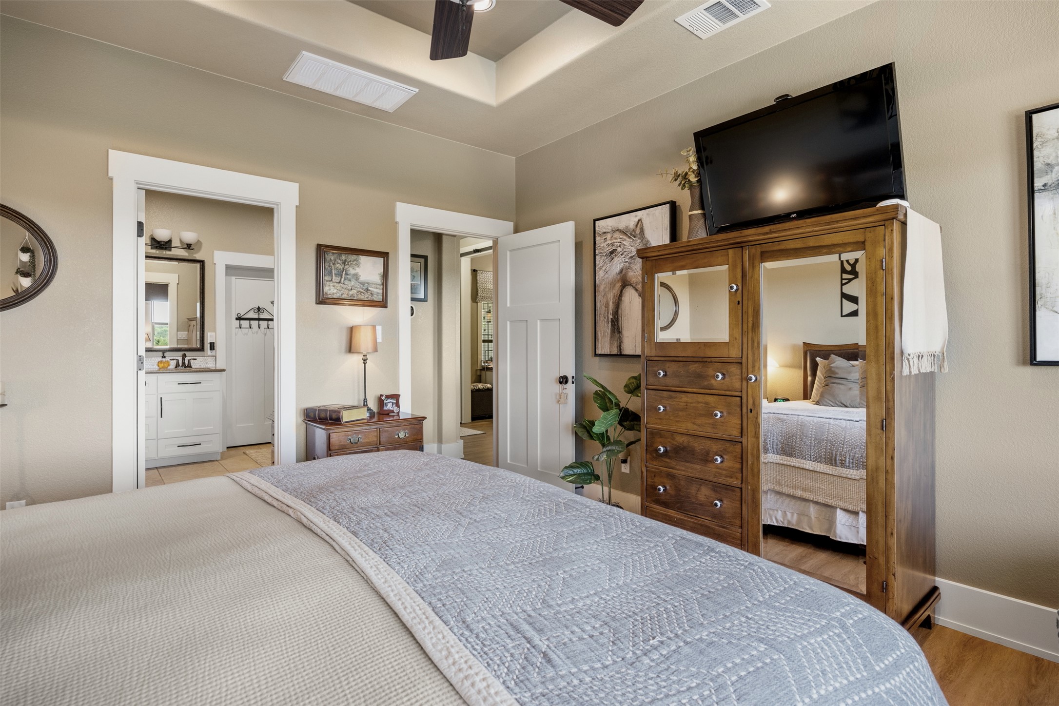 261 Barber Drive Wimberley, TX 78676 - Photo 20 of 37 Bedroom featuring ceiling fan, light wood-style floors, and connected bathroom