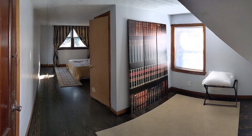 74 Sydney Street, Unit 2 Boston, MA 02125 - Photo 11 of 28 a view of a hallway with wooden floor and a livingroom with furniture