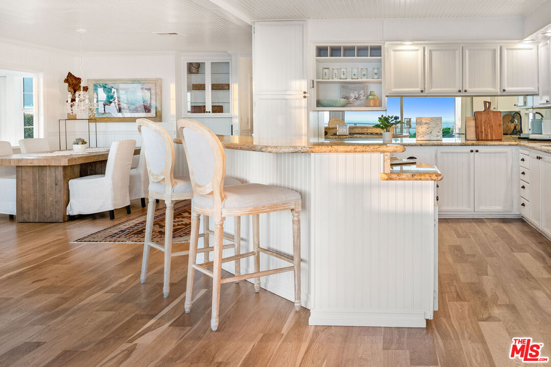 29500 Heathercliff Road, Unit 173 Malibu, CA 90265 - Photo 5 of 27 a kitchen with stainless steel appliances wooden floor and cabinets