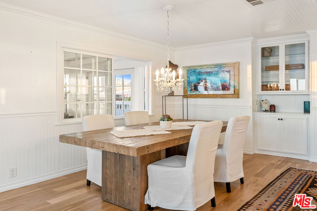 29500 Heathercliff Road, Unit 173 Malibu, CA 90265 - Photo 6 of 27 a dining room with furniture a window and wooden floor