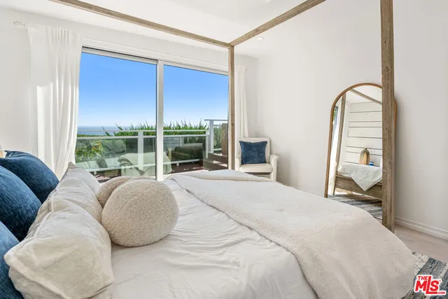 a bed sitting in a bedroom next to a window