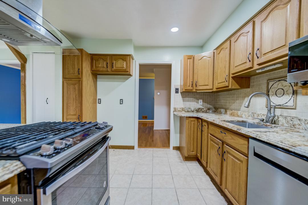 7215 Willow Oak Place Springfield, VA 22153 - Photo 16 of 30 a kitchen with stainless steel appliances granite countertop a sink stove and refrigerator