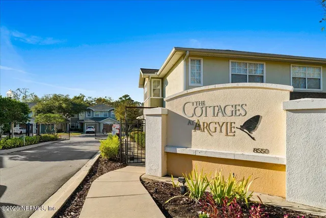 a front view of a house with a yard and potted plants
