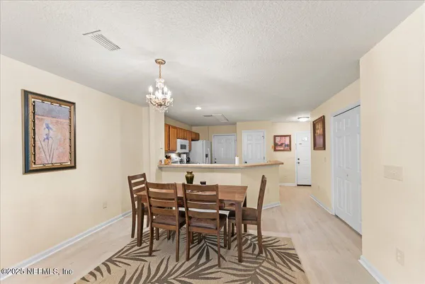 a view of a dining room with furniture and chandelier