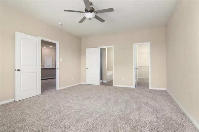 an empty room with a ceiling fan and a window