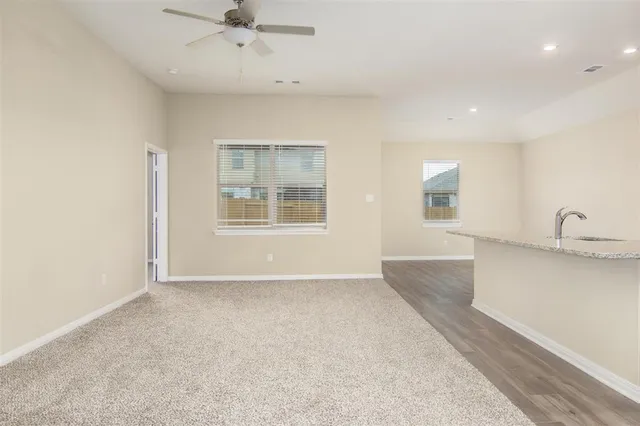 an empty room with windows and fan