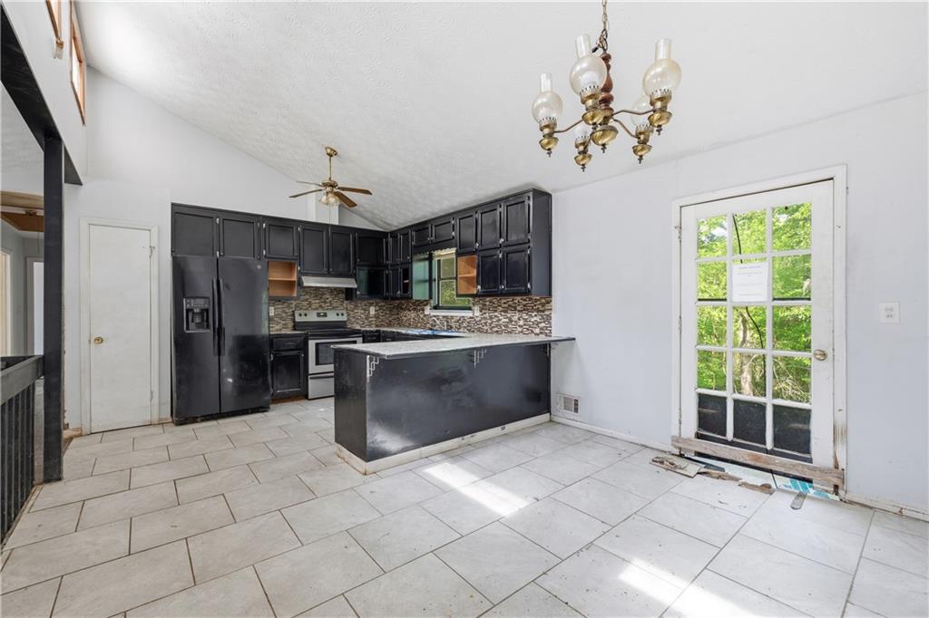 40 Judy Court Stockbridge, GA 30281 - Photo 11 of 20 a kitchen with stainless steel appliances granite countertop a stove a refrigerator a sink a oven with a dining table and chair