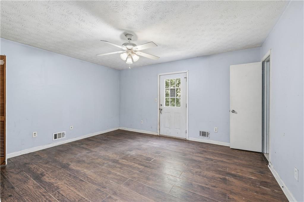 40 Judy Court Stockbridge, GA 30281 - Photo 16 of 20 an empty room with wooden floor ceiling fan and windows