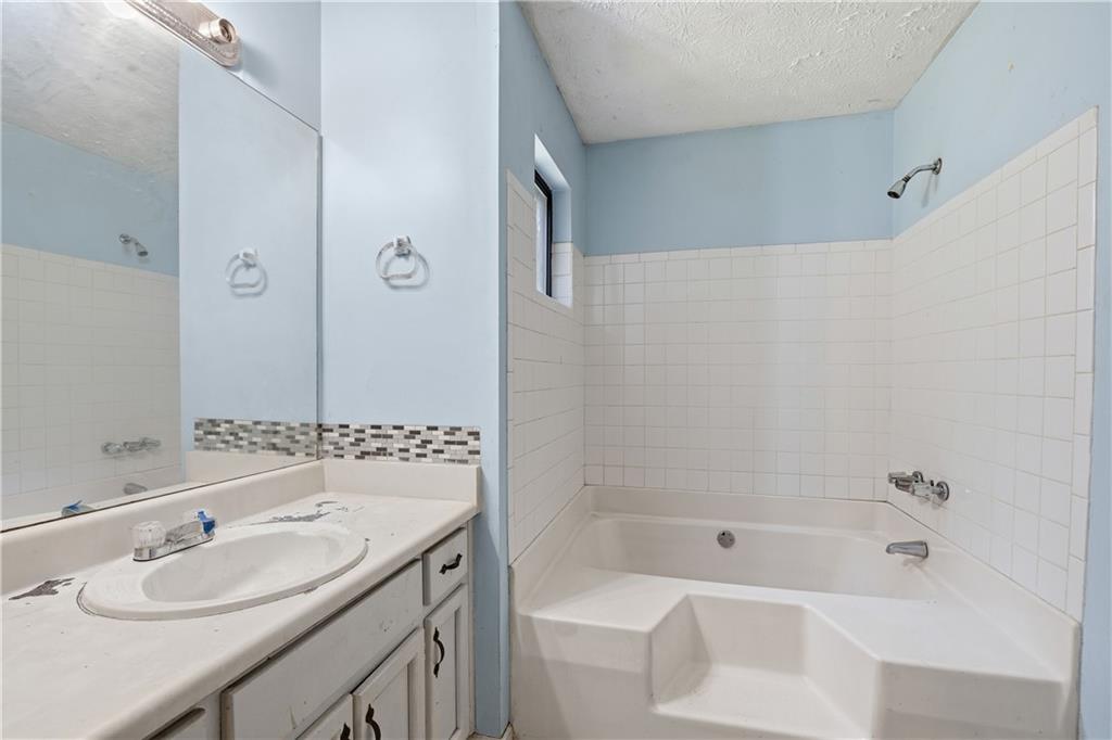 40 Judy Court Stockbridge, GA 30281 - Photo 18 of 20 a bathroom with a sink double vanity granite tub and shower