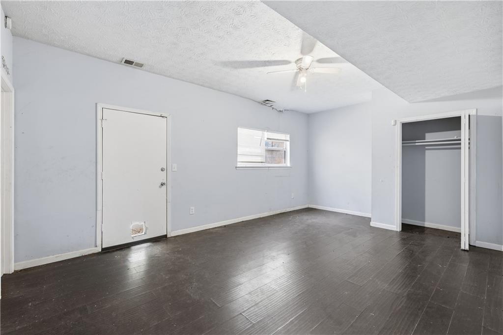 40 Judy Court Stockbridge, GA 30281 - Photo 5 of 20 an empty room with wooden floor chandelier fan and windows