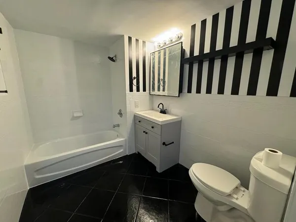a bathroom with a toilet a sink and bathtub