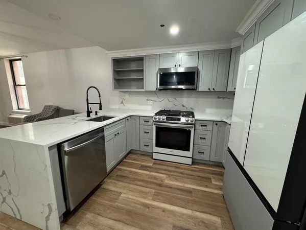 a kitchen with stainless steel appliances a sink stove and refrigerator
