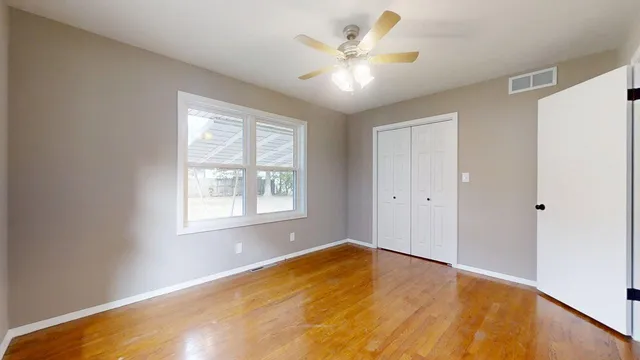 a view of empty room with wooden floor