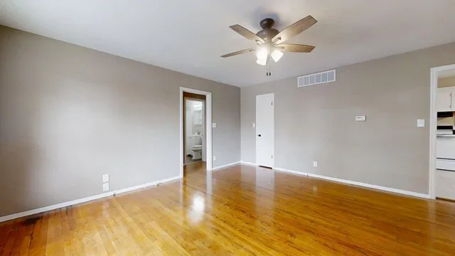 a view of an empty room with wooden floor