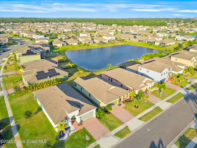 an aerial view of residential houses with outdoor space and swimming pool