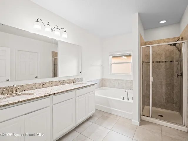 a bathroom with a tub sink shower and mirror