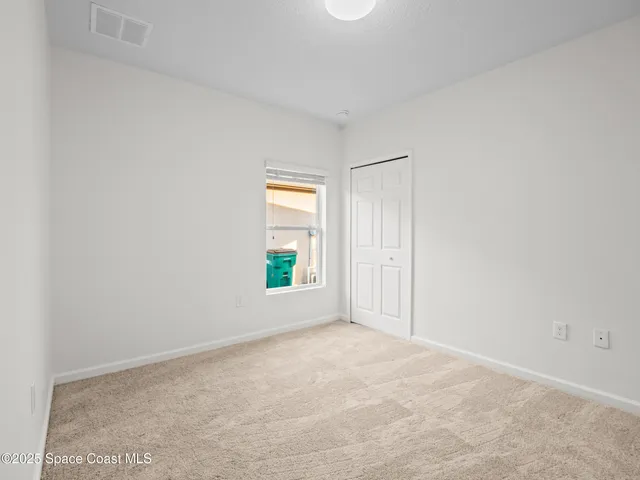 an empty room with windows and closet