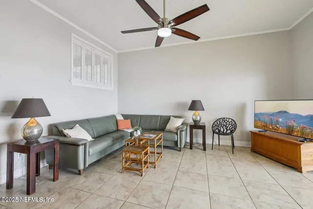 a living room with furniture a flat screen tv and floor to ceiling window
