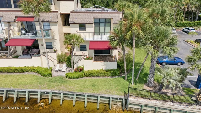 an aerial view of residential houses with outdoor space and lake view